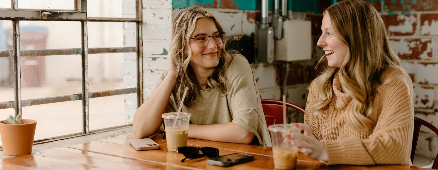 a couple of women sitting at a table with drinks