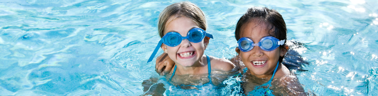 two girls with goggles in a swimming pool